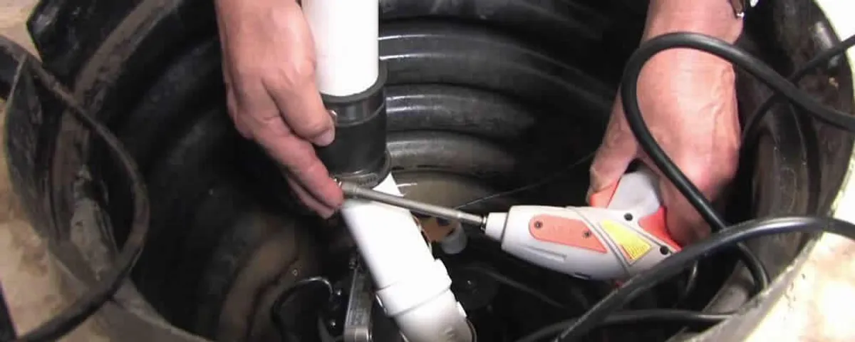 Sump pump installation technician connecting PVC discharge piping in Tucson, AZ
