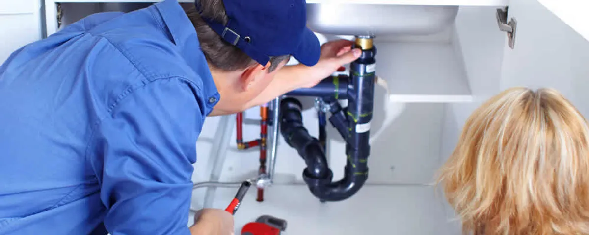 Plumber repairing under-sink drain pipes and fittings in Tucson, AZ